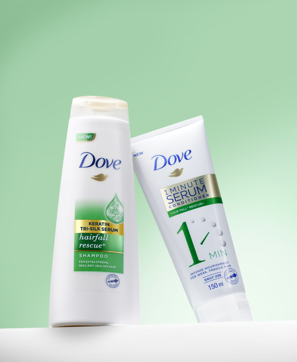 Two bottles of Dove 1 Minute Serum Hairfall Rescue Conditioner and Dove Hairfall Rescue+ Shampoo.