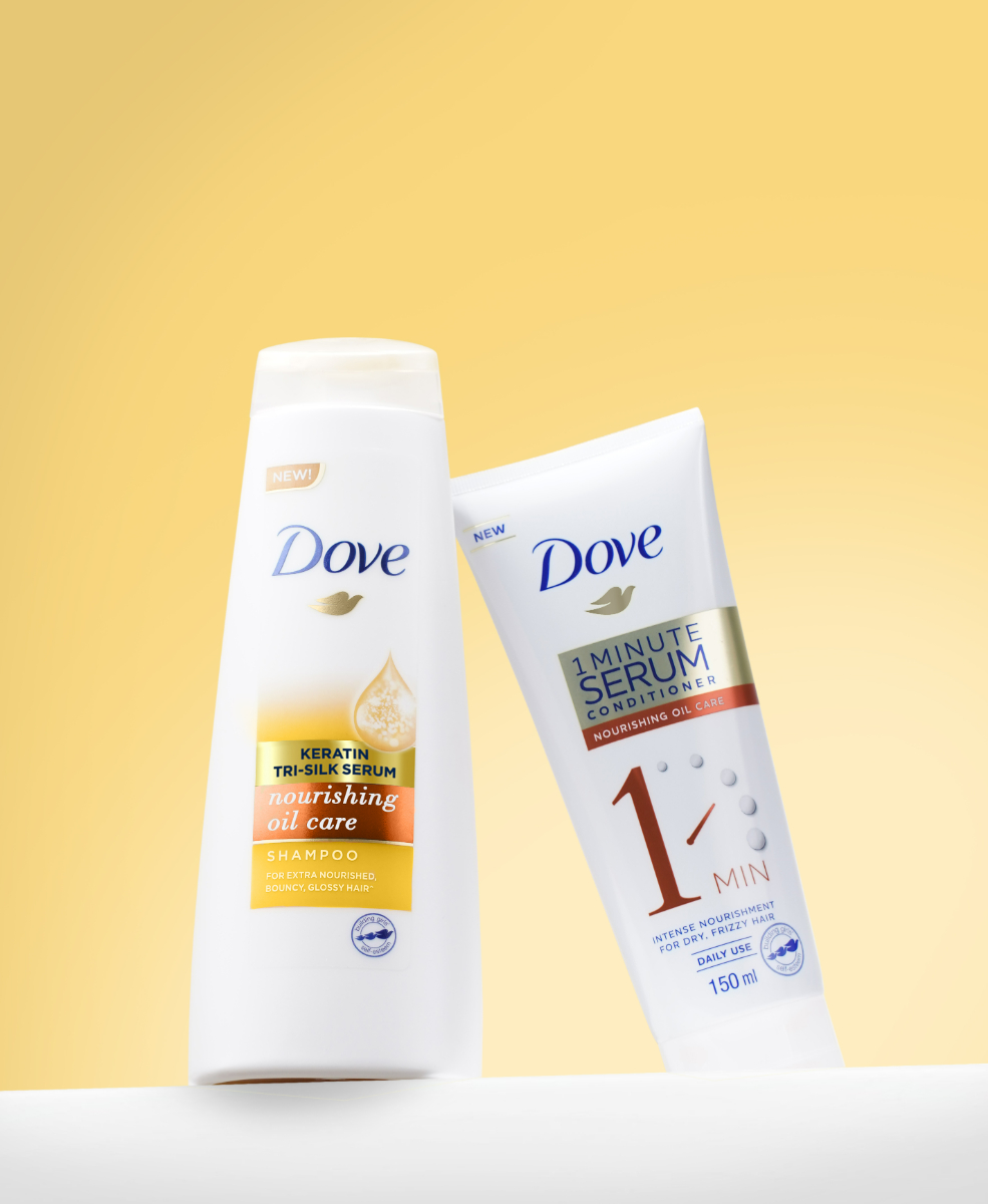 Two bottles of Dove 1 Minute Serum Nourishing Oil Repair Conditioner and Dove Nourishing Oil Repair Shampoo.